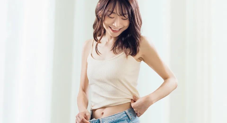 痩せた自分を見ている女性
